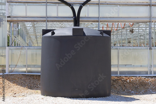 A couple of rain water collection tanks used to catch rain water off of a greenhouse. 