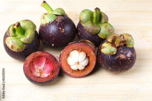 Mangosteen and cross section showing the thick purple skin