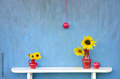 still-life with red vases and flowers on white shelf photo