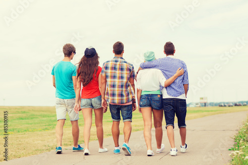 group of teenagers walking outdoors from back