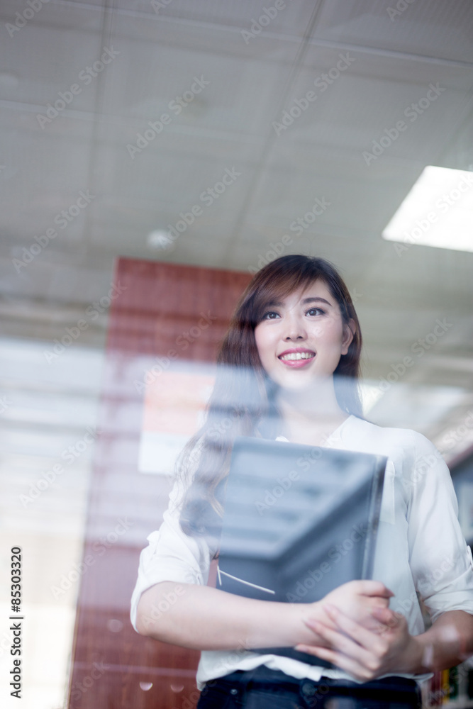 Asian female student looking book in library