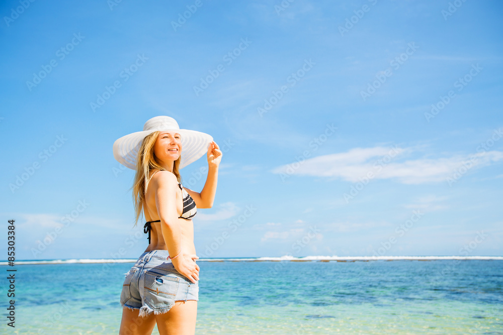 Young skinny caucasian girl with tan stays on the rock facing Young skinny caucasian girl with tan stays on the rock facing