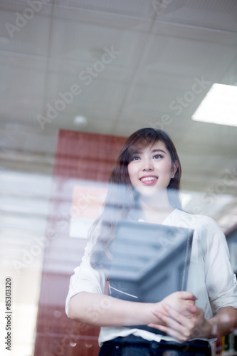Free Download Asian female student looking book in library - GFXLoad