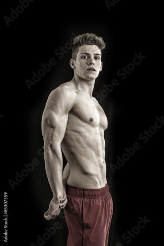 Handsome young bodybuilder in triceps pose