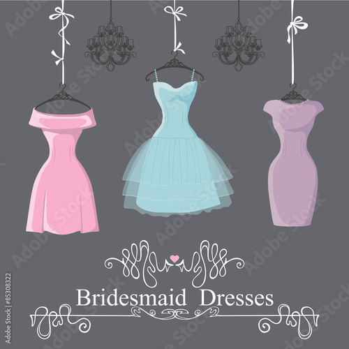 Three short bridesmaid dresses hang on ribbons