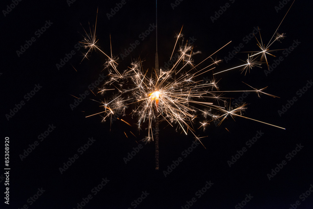 hand holding a sparkler fire on black background