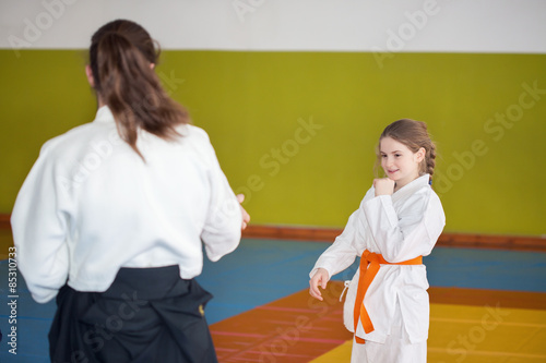 A young girl practice Aikido with her instructor