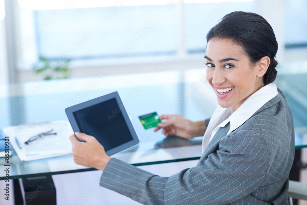 Businesswoman doing online shopping in office Businesswoman doing online shopping in office
