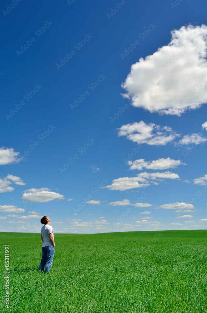 young man looks at the bright sky over the green field young man looks at the bright sky over the green field