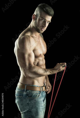 Man with rope During training, muscular body on black