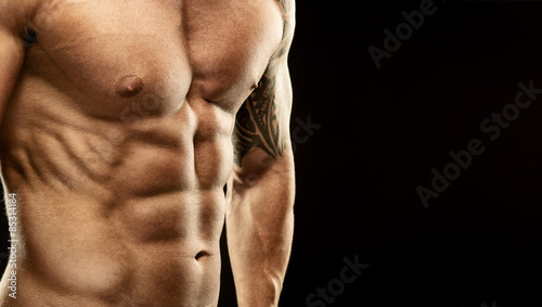 Men's muscular abdomen - close-up - on black background