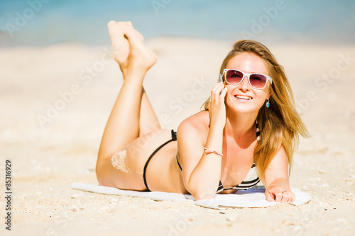 Sexy young blond girl in sunglasses speaking on the phone