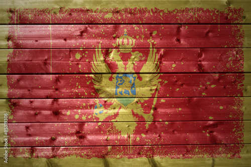 painted montenegrin flag on a wooden texture