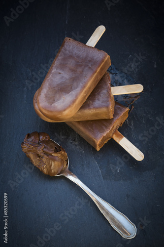 Nutella popsicle, spoon with Nutella on slate photo