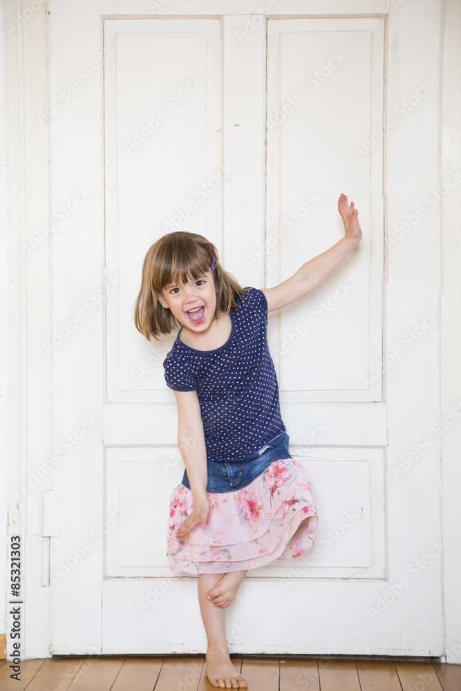 Happy girl dancing at wooden door Happy girl dancing at wooden door