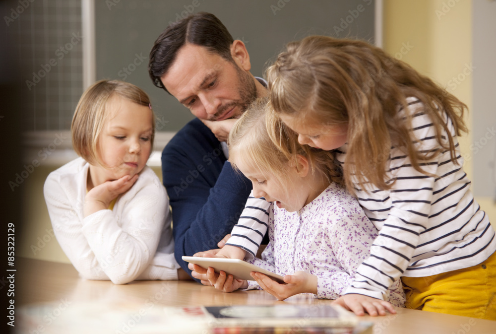 Teacher with schoolgirls using digital tablet in classroom Teacher with schoolgirls using digital tablet in classroom