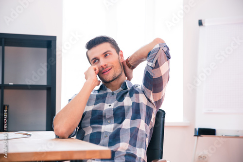 Young businessman speaking on the phone in office