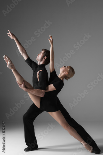 Fototapeta Naklejka Na Ścianę i Meble -  two young modern ballet dancers on gray studio background 