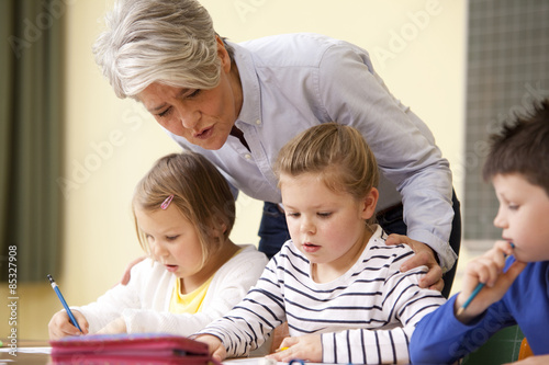 Teacher with pupils in classroom photo