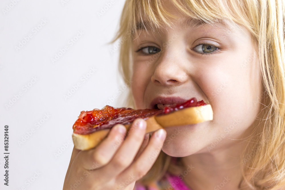 Portrait of blond girl eating bread with jam Portrait of blond girl eating bread with jam