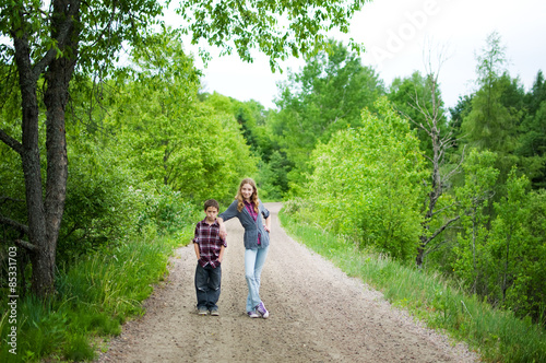 brother and sister on a trail outdoors in summer © sianc