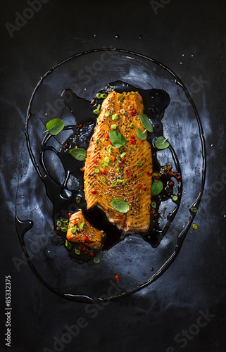 Food art, salmon with hot pepper, red chili black sesame, spring onion, paprika, herbs, oil and marinade photo