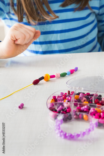 Girl stringing pearls