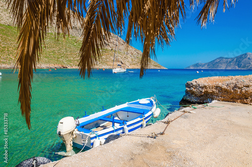 Blue and white wooden boat in cosy Greek port photo