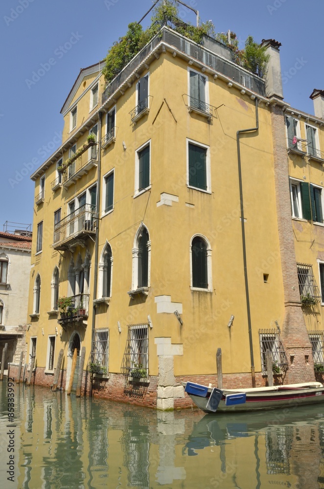 Yellow building over canal in Venice, Italy