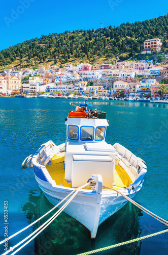 Colorful boat with yellow deck moored in Greek bay