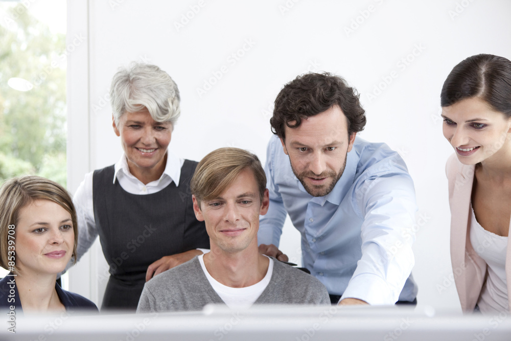 Smiling business team working on computer in office Smiling business team working on computer in office