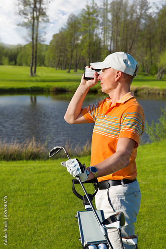 man golfer watching into rangefinder