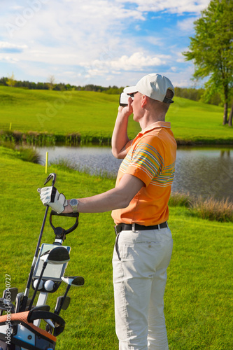 man golfer watching into rangefinder