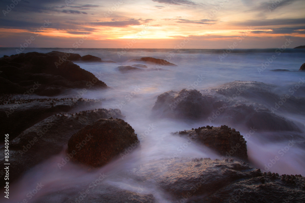 Seascape with motion water hitting rocks