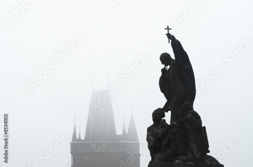 Czech Republic, Prague, statue on Charles Bridge in morning fog
