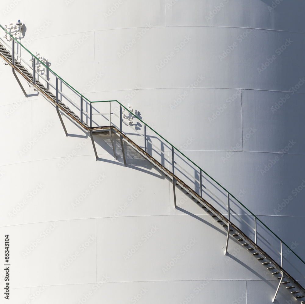 white tanks in tank farm with iron staircase white tanks in tank farm with iron staircase