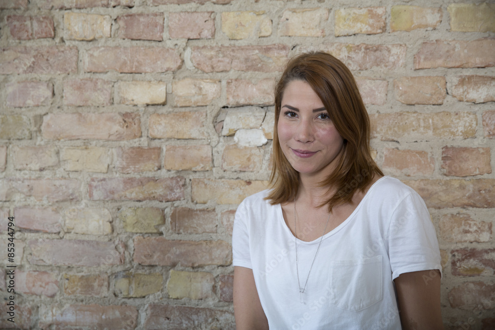 Portrait of young woman in front of brick wall Portrait of young woman in front of brick wall