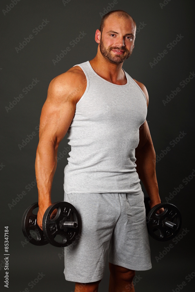 Muscular man in gay shirt poses with dumbbell
