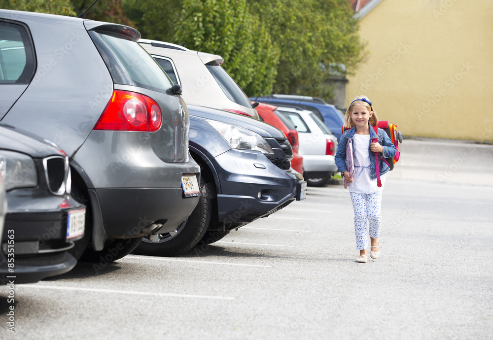 Little girl on her school way crossing parking area Little girl on her school way crossing parking area