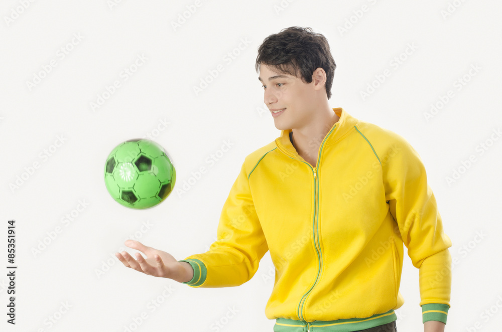 Young man throwing a football ball. Attractive man playing with a ball in the hands. Young man throwing a football ball. Attractive man playing with a ball in the hands.