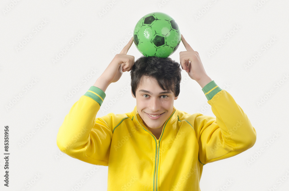 Young man holding up a football ball. Attractive man holding a ball in the hands over his head. Young man holding up a football ball. Attractive man holding a ball in the hands over his head.
