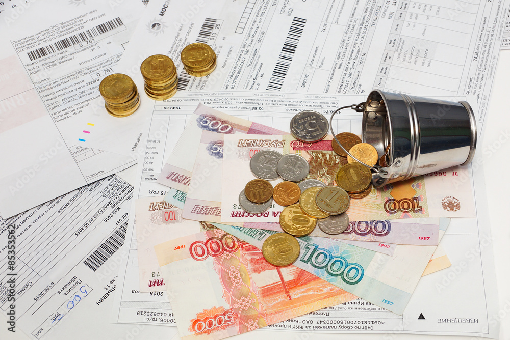 Φωτογραφία Российские деньги,коммунальные квитанции и ведро с монетами.
