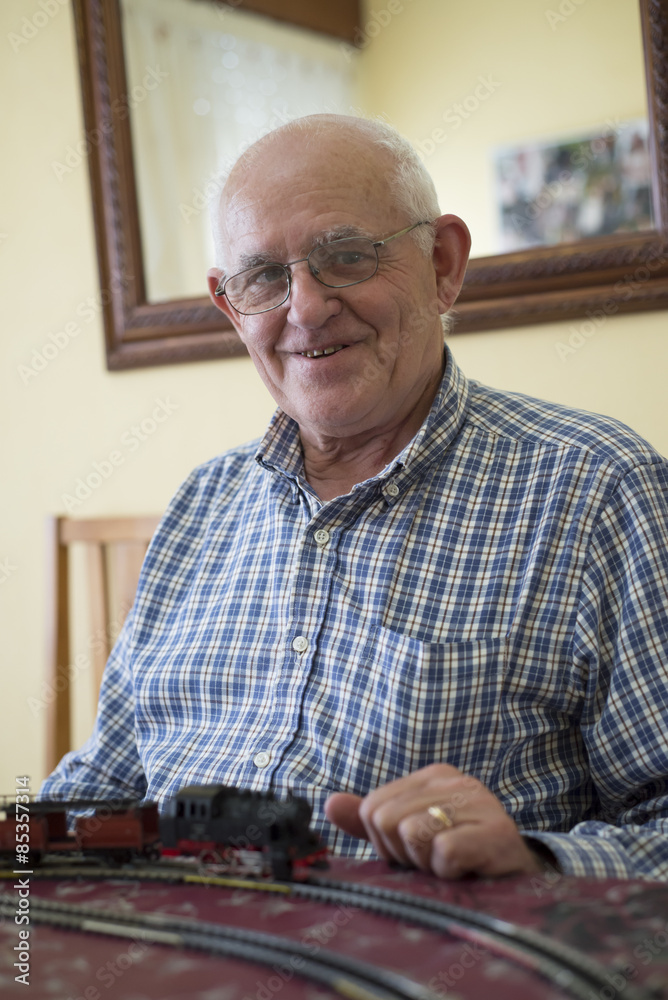 Portrait of smiling senior man with his model railway Portrait of smiling senior man with his model railway