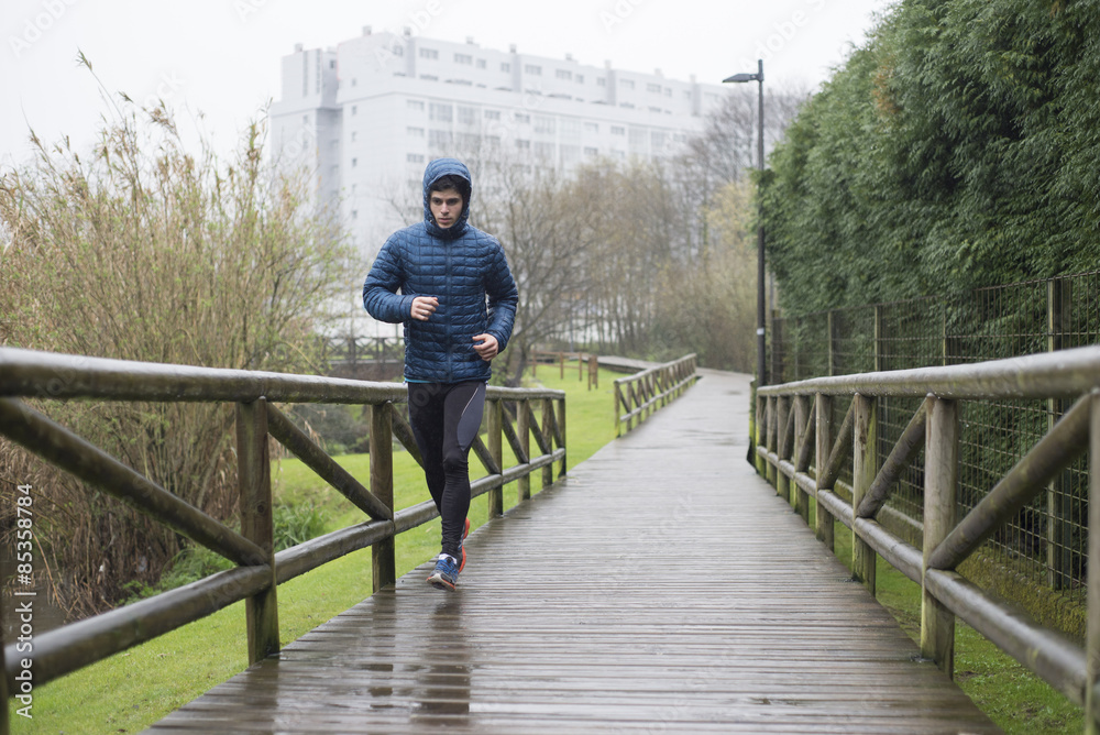 Spain, Galicia, Naron, runner on a promenade in park at a rainy day Spain, Galicia, Naron, runner on a promenade in park at a rainy day