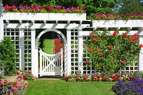 Fototapeta Naklejka Na Ścianę i Meble -  White garden gate with flowers