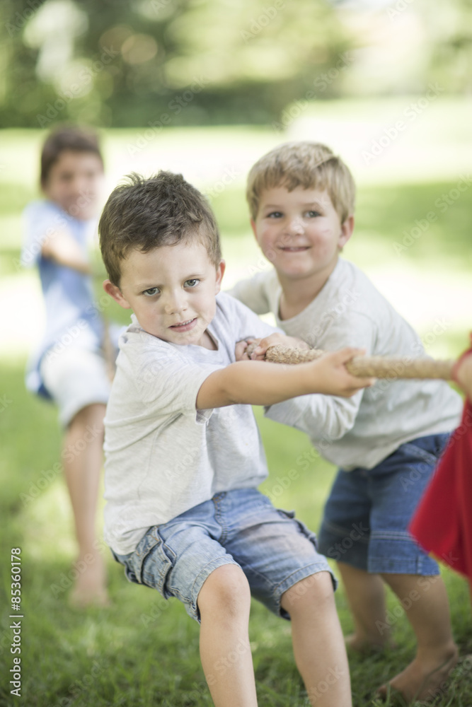 Kids in garden playing tug of war Kids in garden playing tug of war