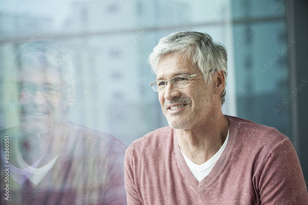 Portrait of smiling man looking through window Portrait of smiling man looking through window