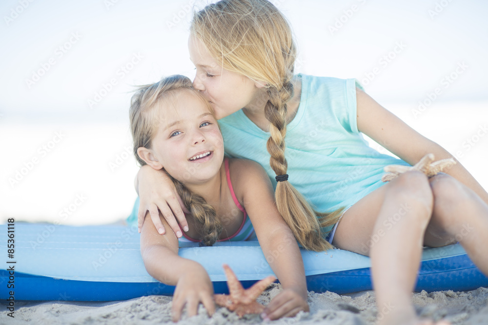 Two happy girls on beach on a inflatable raft Two happy girls on beach on a inflatable raft