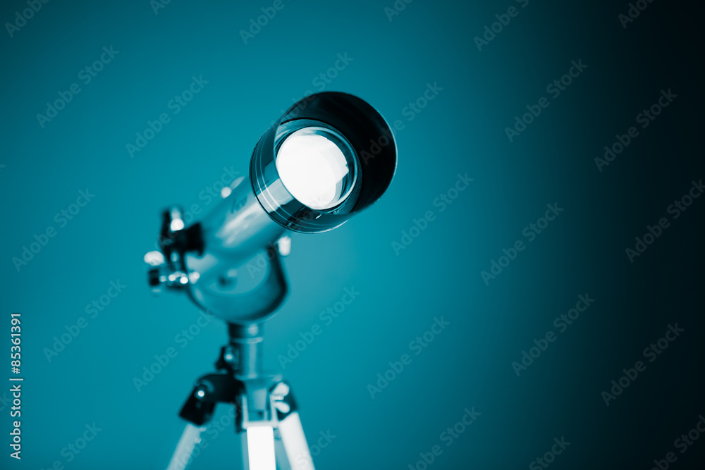 Fototapeta premium telescope on blue background with copy-space