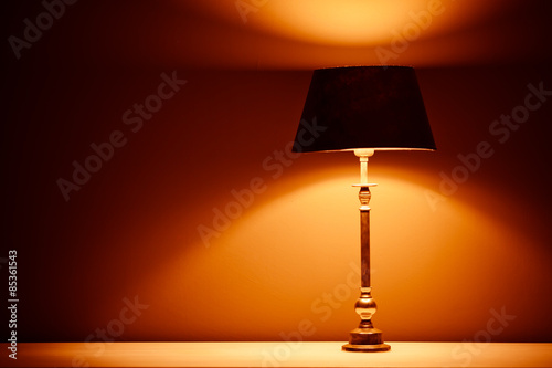 interior lamp with warm light against plaster wall background